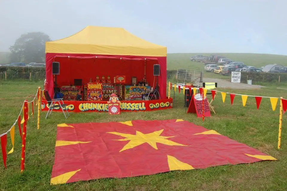 Chunkie Russell's red and yellow big top stage set up on a field for a family fun day