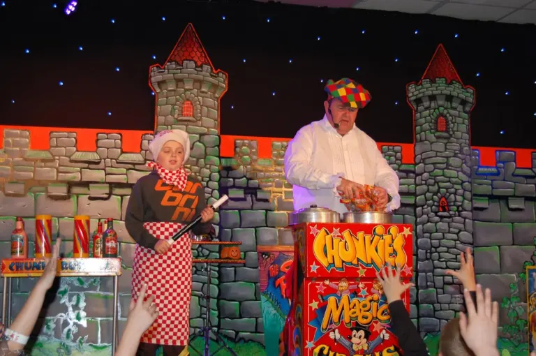 Chunkie Russell performing a magic show on a castle-themed stage