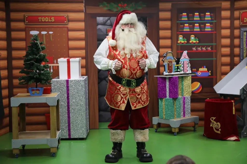 Father Christmas standing in his festive grotto workshop