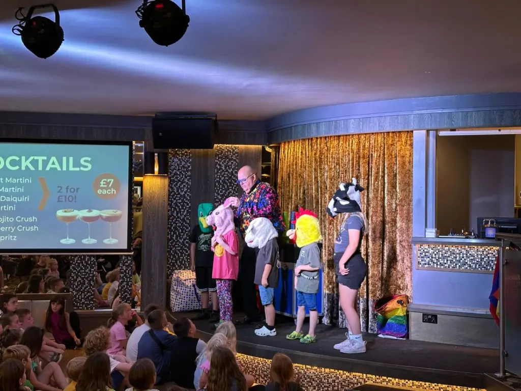 Chunkie leading a holiday park stage show with children and costume characters