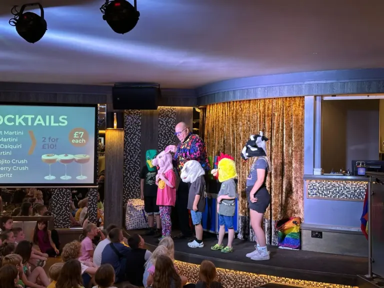Chunkie leading a holiday park stage show with children and costume characters