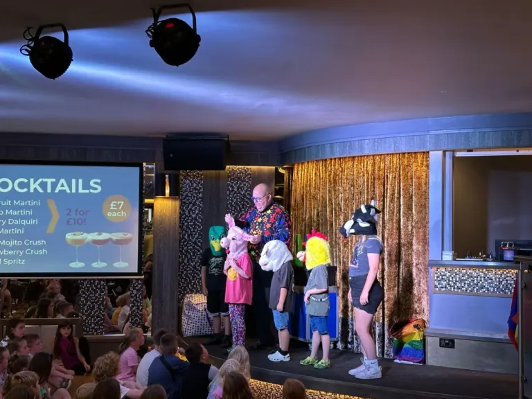 Children joining Chunkie on stage at a holiday park family show
