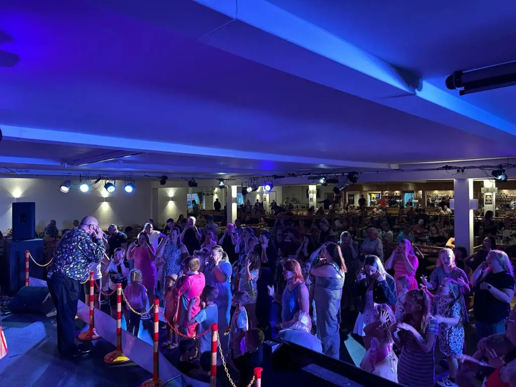 A packed evening family show with children dancing in front of the stage