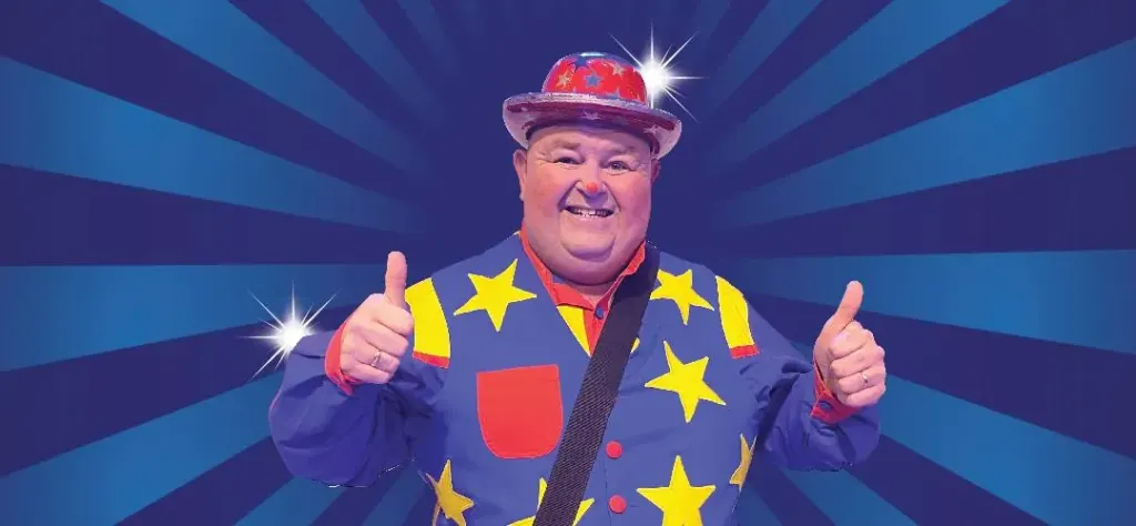Tommy Tumble the clown giving two thumbs up in his star-covered costume
